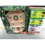 Four boxed Christmas decorations to include a Santa's Musical Workshop,