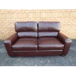 A modern two seater brown leather sofa (minimal use), approximate height 110 cm x 175 cm x 90 cm.