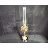 A Veritas glass and brass oil lamp, approximately 71 cm (h) including chimney.