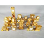 23 miniature brass clocks of varying form.