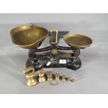 A set of Libra Scales Co cast iron weighing scales with brass pans with a set of seven brass