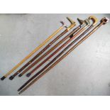 A collection of walking sticks to include an example with brass handle in the form of a ducks head,