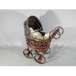A vintage miniature pram, ca 1950s with ceramic headed doll of the period,