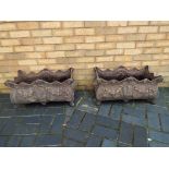 A matched pair of ornate cast iron garden planters approximate height 30 cm x 65 cm x 45 cm [2].