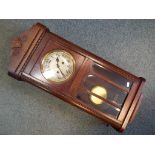 A mahogany cased wall clock, Arabic numerals, with key and pendulum.