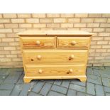 A pine two over two drawer chest of drawers approximate height 71 cm x 92 cm x 46 cm.