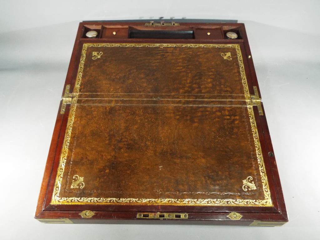 A mahogany and brass bound campaign writing slope with flush brass handles with one end having - Image 4 of 4