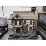 An outstandingly detailed large Tudor style doll's house in naturalistic garden setting,