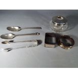 A quantity of silver items to include two napkin rings, silver tongs and similar.
