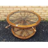 A good quality unusual oak coffee table in the form of a ships wheel with glass top,