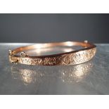 9 ct - a hallmarked 9 carat rose gold bangle with safety chain, approximate weight 5.2 g.