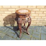 An early 20th century Chinese pink marble and padouk wood plant stand,