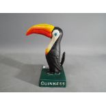 A cast metal sign in the style of a Guinness Toucan