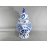 A large late 19th century large covered urn shaped vase hand painted in blue and white,