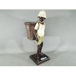 A figurine of a black boy with a basket (a/f)