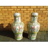 A very large pair of Chinese 19th century Canton, famille rose vases and covers,