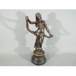 An Art Nouveau spelter figurine depicting a diaphanous clad maiden, raised on wooden plinth,