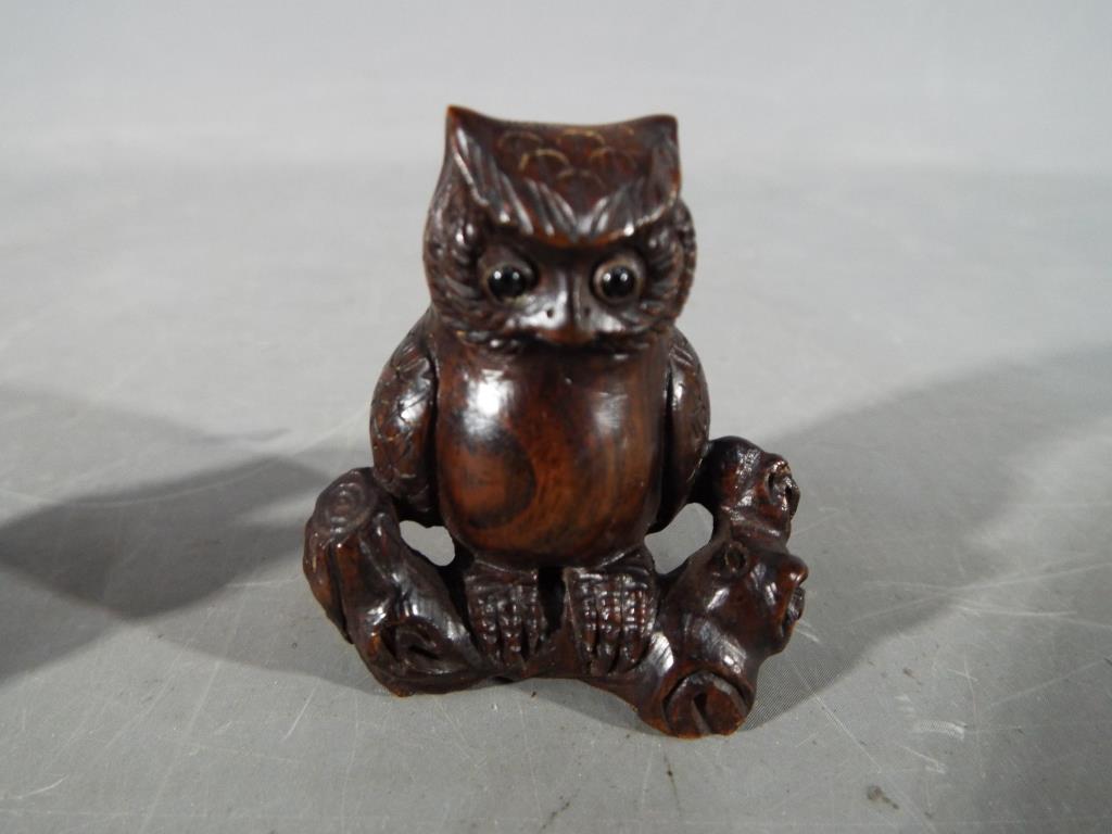 A vintage Japanese dark wood Netsuke depicting an Owl seated on a thick branch or log, - Image 2 of 7
