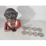 A vintage cast iron mechanical money bank in the style of a black man,