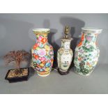 Two Chinese vases the largest with floral and insect decoration, temple lion handles,