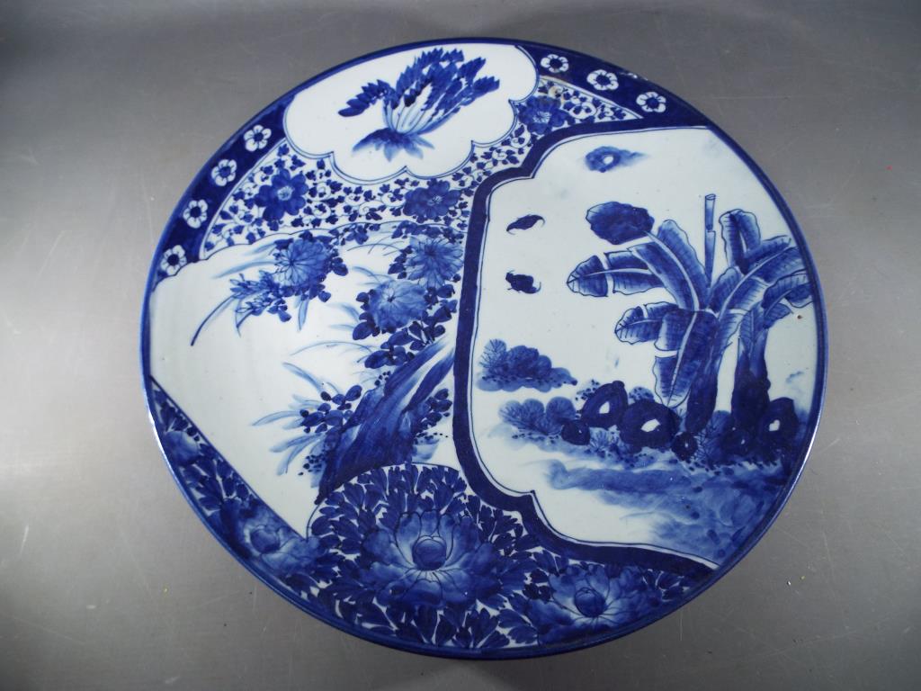 A Meiji period blue and white Arita charger painted with design of overlapping fans decorated with
