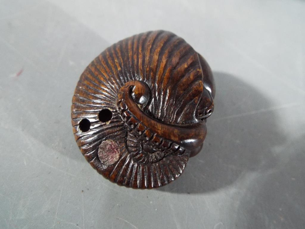 A vintage dark wood Netsuke depicting a small frog type animal carrying a large tree trunk on its - Image 3 of 6