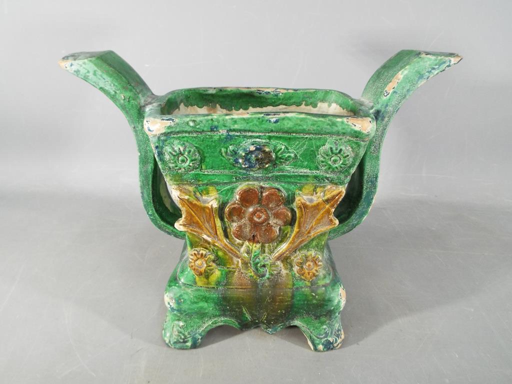 A Chinese Tang dynasty sancai glaze twin handled vessel, with floral decoration,