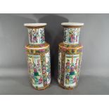 A matched pair of Oriental vases decorated with alternating panels depicting courtly scenes and