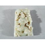 A small Chinese rectangular jade plaque depicting a central figure surrounded by mythical creatures,