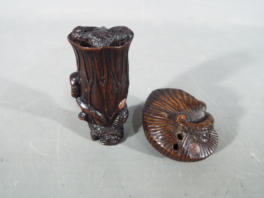 A vintage dark wood Netsuke depicting a small frog type animal carrying a large tree trunk on its - Image 2 of 6