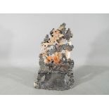A Chinese soapstone carving of a landscape scene with a seated gentleman to the centre,