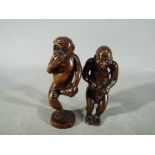 A vintage dark wood Japanese erotic Netsuke depicting an Oriental gentleman,