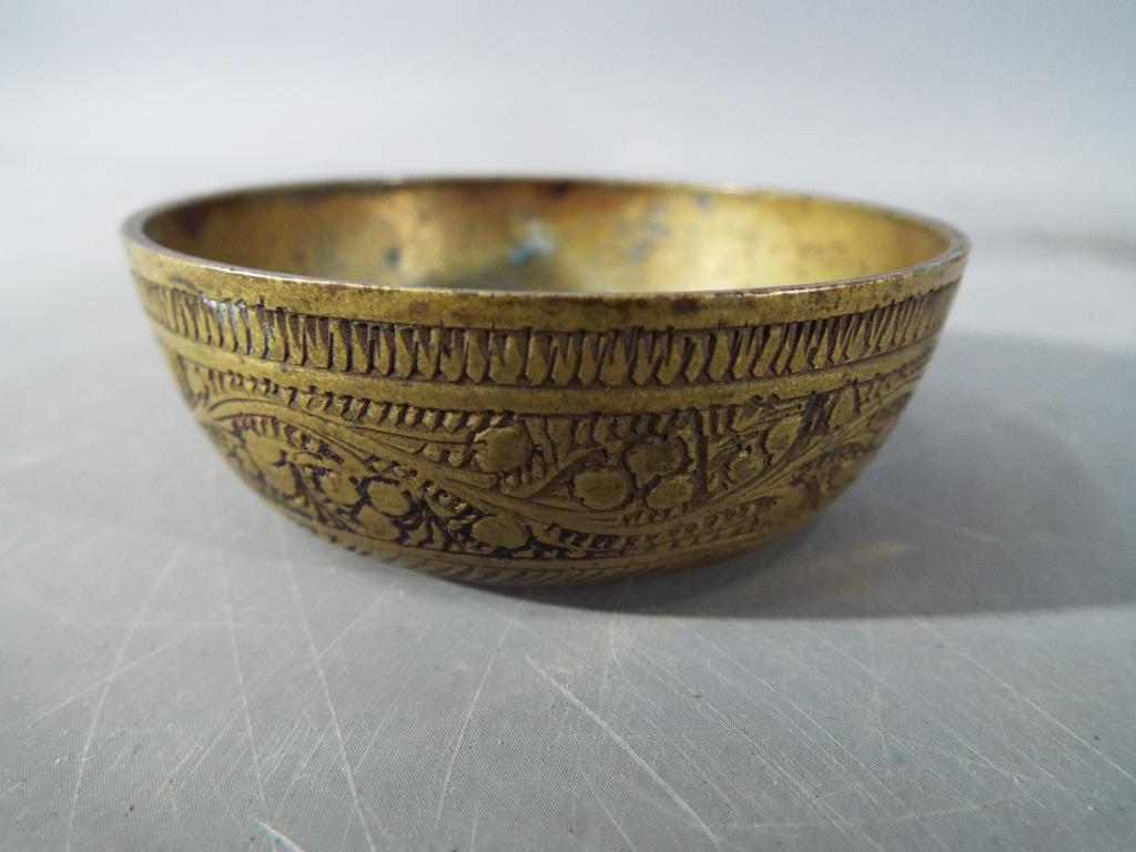 Four middle eastern metal dishes, comprising four bowls and a cup having chased decoration. - Image 4 of 6