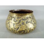 A middle eastern gilt bowl with repoussé decoration depicting fauna and mythical creatures,