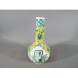 A small Chinese bottle vase decorated with panels depicting warriors on a yellow ground with