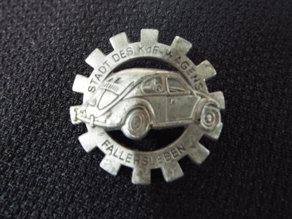 A white metal pin badge displaying a German motor vehicle
