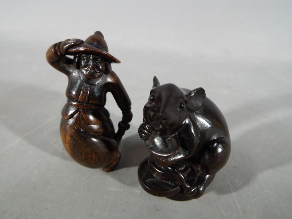 A vintage Japanese dark wood Netsuke depicting a large mouse or rat carrying its catch, - Image 3 of 5