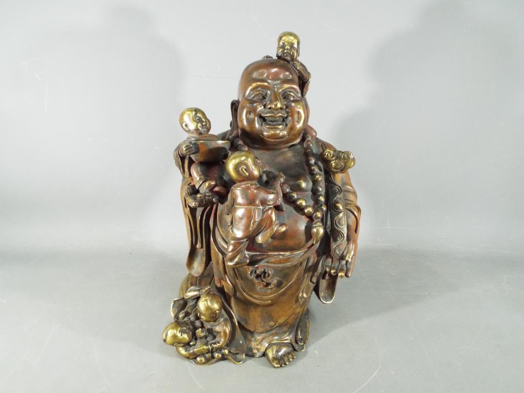A large Chinese gilt bronze laughing Buddha with five children holding Ruyi sceptre,