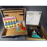 A briefcase containing a 1959 Rupert the Bear annual, BBC book of Crackerjack,