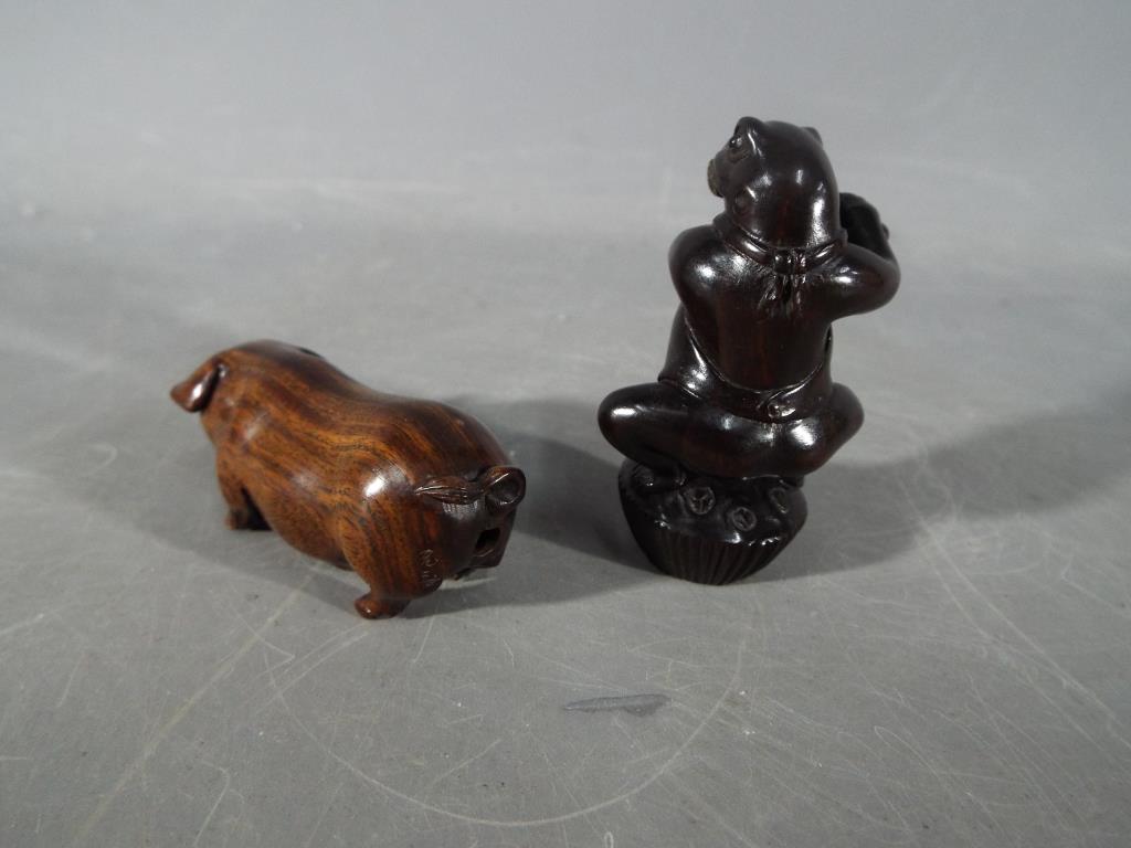 A vintage Japanese dark wood Netsuke depicting a frog type creature possibly playing a flute, - Image 2 of 3