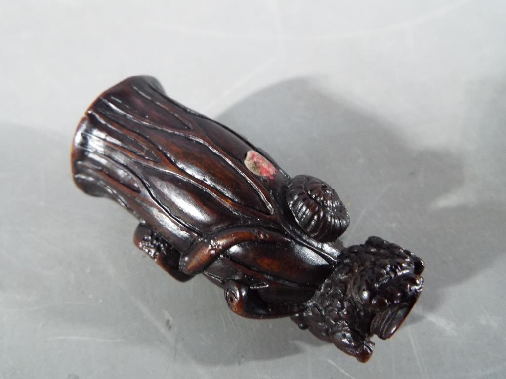 A vintage dark wood Netsuke depicting a small frog type animal carrying a large tree trunk on its - Image 5 of 6