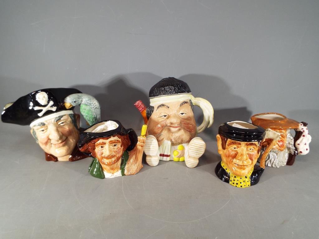 A collection of character jugs and a novelty teapot.