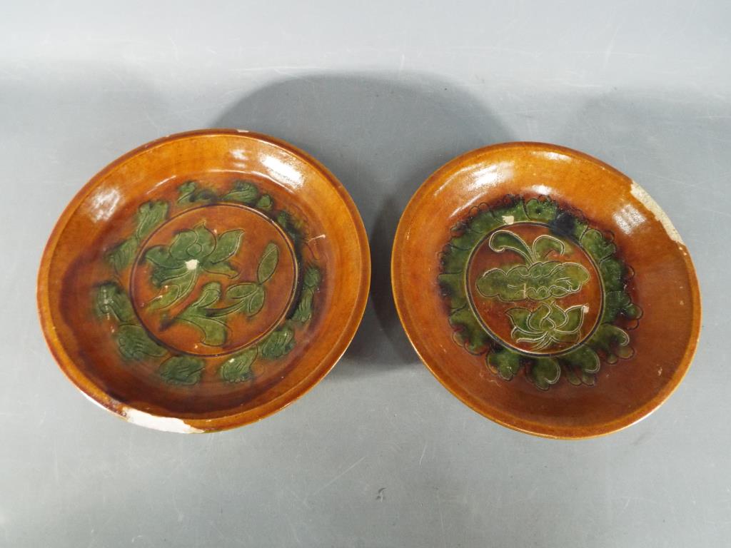 A pair of rare Chinese Tang dynasty sancai glaze terracotta dishes raised on tripod supports with