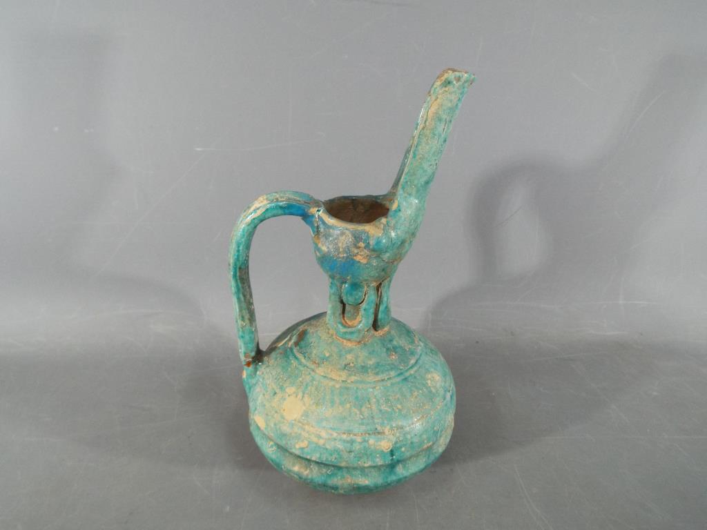 A rare middle eastern turquoise glazed jug of waisted globular form with elongated pouring spout,