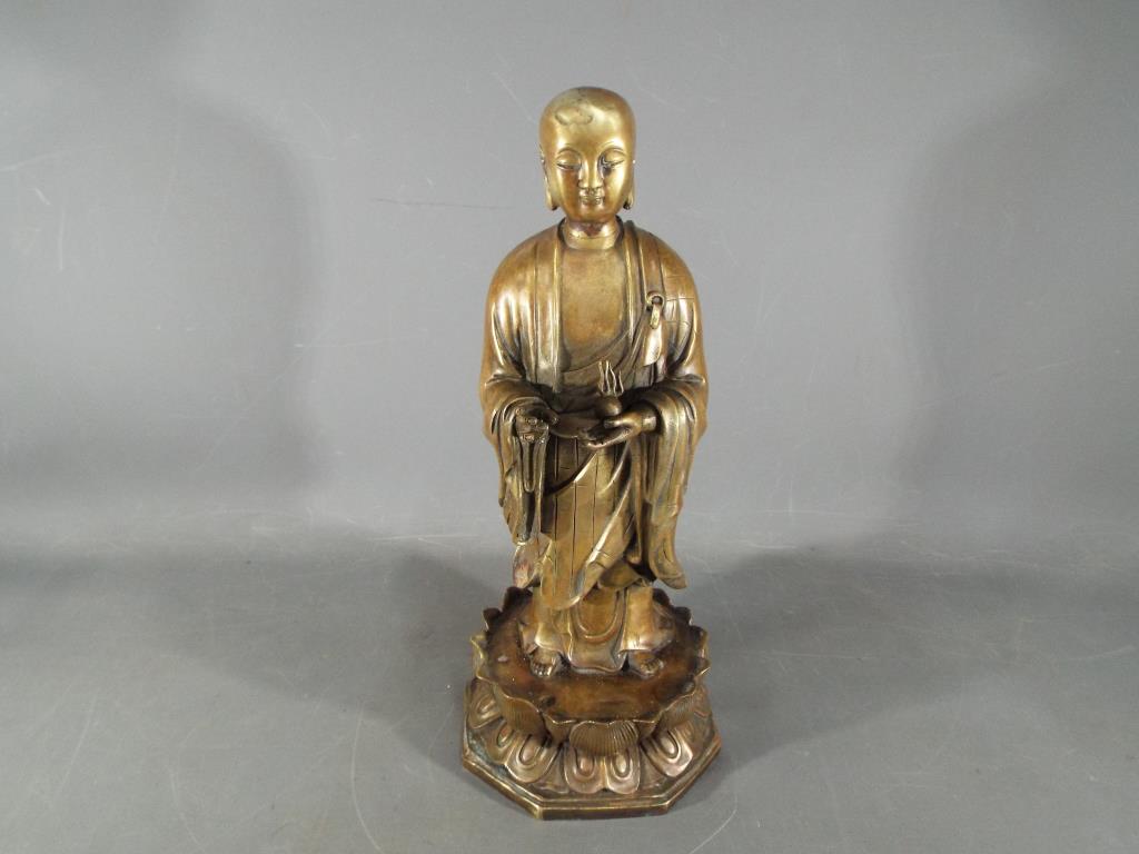 A rare, Chinese Tibetan large gilt bronze depicting Ananda, standing on a lotus base,