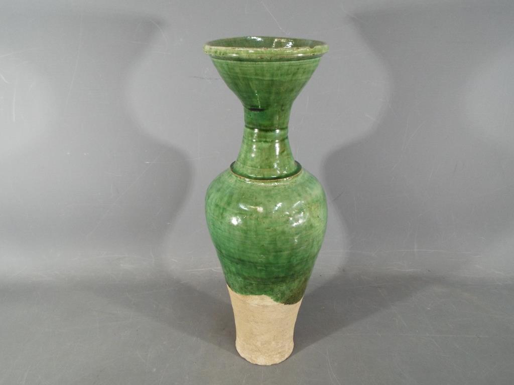 A Chinese Tang dynasty sancai glaze vase of mis-shapen form, unglazed to lower section,