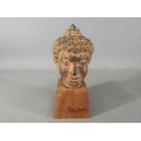 A Thai bronze Buddha head, likely pre-18th century, on wooden stand,