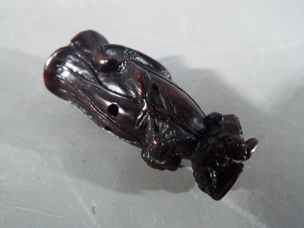 A vintage dark wood Netsuke depicting a small frog type animal carrying a large tree trunk on its - Image 4 of 6