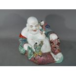 A rare Chinese famille rose laughing Buddha holding prayer beads, with two attendants,