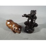 A vintage Japanese dark wood Netsuke depicting a frog type creature possibly playing a flute,